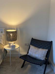 a black bench sitting next to a table with a lamp at Cosy 1 bedroom in Abingdon