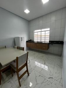 an empty kitchen with a table and a refrigerator at Apartamento no Centro de Sengés Quarto 01 in Sengés