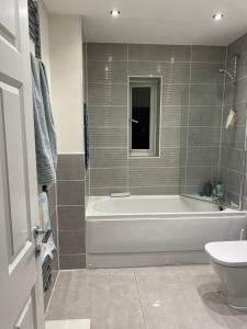 a bathroom with a tub and a toilet and a sink at Cosy 1 bedroom in Abingdon
