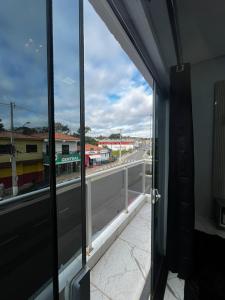 an open door to a balcony with a view of a street at Apartamento no Centro de Sengés Quarto 01 in Sengés