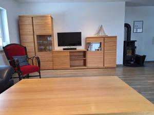 a living room with a tv and a table and chairs at Huus 8 in Westoverledingen