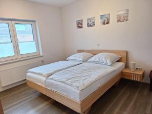 a bedroom with a large bed and a window at Huus 8 in Westoverledingen