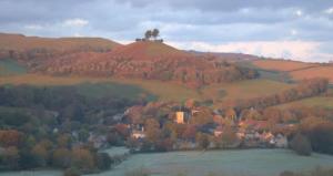 a house on top of a hill next to a river at Oligrae Cottage in Bridport