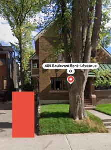 a tree in front of a house with a sign at La Pergola-3 in Quebec City +6 photos