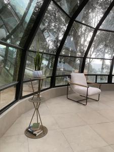 a room with a chair and a table and windows at Mineral Glamping Experience in Mineral del Chico
