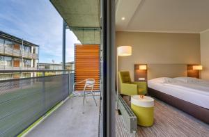 a hotel room with a bed and a balcony at GenoHotel Baunatal in Baunatal +20 photos