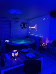 a room with a jacuzzi tub in a dark room at Suite Eden Spa, Appart'hôtel bien être , Patio de standing barbecue - TV XL CinéSport, Lit Q-Size, Wifi, P-Gratuit en Résidence in Avion +32 photos