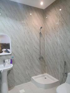 a bathroom with a shower with a toilet and a sink at Quiet Rooms 7 Serviced Apartments in Riyadh