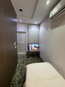 a bedroom with a bed and a tv in a room at Quiet Rooms 7 Serviced Apartments in Riyadh +53 photos