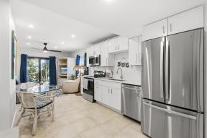 a kitchen with a stainless steel refrigerator and a table at Sea Dunes Nautilus B8 in New Smyrna Beach