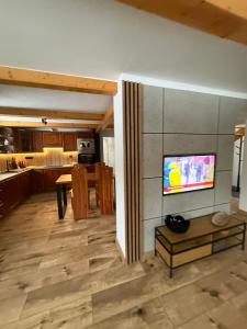 a living room with a television on a wall at Chata Diana in Oravice