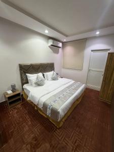 a bedroom with a large bed in a room at Quiet Rooms 7 Serviced Apartments in Riyadh