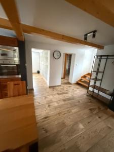 a kitchen with a clock on the wall and a wooden floor at Chata Diana in Oravice