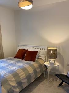 a bedroom with a bed and a lamp on a table at Cosy 1 bedroom in Abingdon