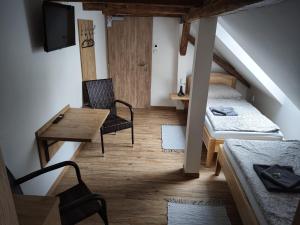 a small room with a bed and a table and chair at Penzion U Koruny in Ústí nad Labem