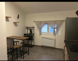 a kitchen with a table and a table and a window at Chez aurelie in Agnin