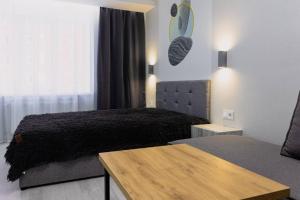 a bedroom with a bed and a wooden table at Center 2 poverh Ecoflow VIP TopApart in Sumy