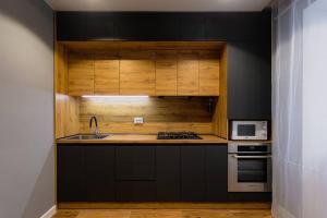 a kitchen with black cabinets and a sink at Center 2 poverh Ecoflow VIP TopApart in Sumy