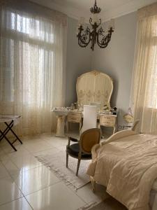 a bedroom with a bed and a table and chairs at Graeco-Roman Residence-Delilah in Alexandria