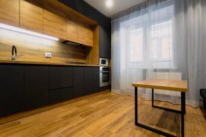 a kitchen with a wooden table and a window at Center 2 poverh Ecoflow VIP TopApart in Sumy +17 photos
