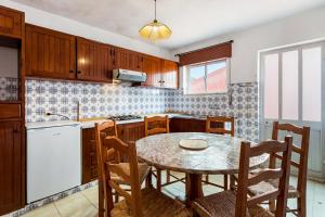 a kitchen with wooden cabinets and a table and chairs at El Shaddai 3 in Atalaia