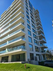 a tall building with a grassy hill in front of it at Apart HOTEL VOGH OLIMP - S605 in Văleni +4 photos