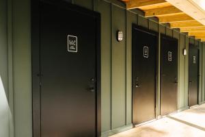 a row of black doors in a hallway at Ferncrest Campground in Greentown