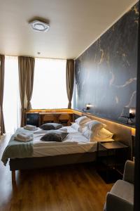 a bedroom with a large bed and a blue wall at Boutique Hotel & Event Center in Budapest