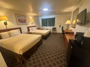 a hotel room with two beds and a television at Canyonlands Motor Inn in Monticello