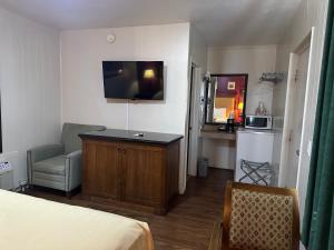 a bedroom with a bed and a desk and a chair at Canyonlands Motor Inn in Monticello