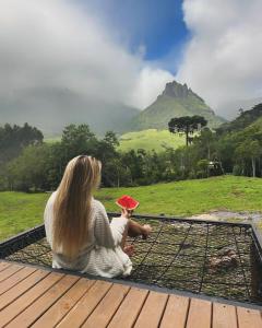a woman sitting on a bench holding a toy at Cabana do Céu - Soldados Sebold in Alfredo Wagner +6 photos