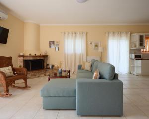 a living room with a blue couch and a fireplace at Modern retreat near Ancient Olympia and sandy beach in Káto Samikón