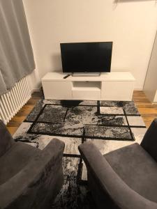 a living room with a tv and a white table at BR Apartment in Kiel +3 photos