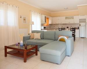 a living room with a blue couch and a table at Modern retreat near Ancient Olympia and sandy beach in Káto Samikón