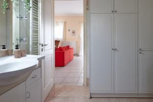 a bathroom with a white sink and a red couch at Modern retreat near Ancient Olympia and sandy beach in Káto Samikón +28 photos