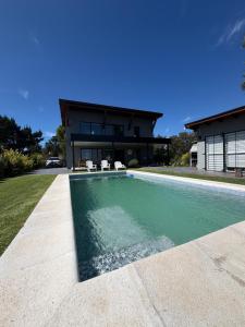 a swimming pool in front of a house at Sol de campo in Santa Clara del Mar