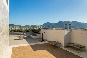 a balcony with benches and a view of a city at Conforto e Localização perfeita Centro RJ 20 min Copacabana e Piscina in Rio de Janeiro