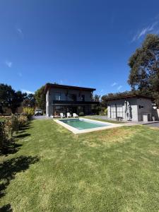 a house with a swimming pool and a yard at Sol de campo in Santa Clara del Mar