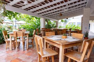 an outdoor patio with wooden tables and chairs at Hotel Suites Villasol in Puerto Escondido