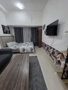 a living room with a couch and a tv on the wall at Apartment condo in Ajman in Ajman  +10 photos