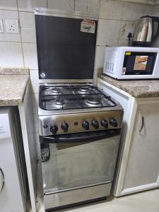 a stove in a kitchen with a microwave at Apartment condo in Ajman in Ajman 