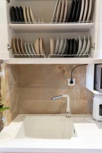 a kitchen with a sink and a shelf with dishes at Kos View City , Luxury Old Town in Kos +30 photos