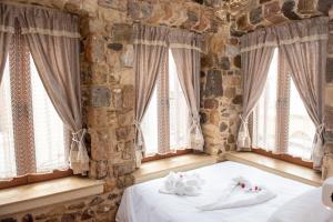 a bedroom with windows with white towels on a bed at Kos View City , Luxury Old Town in Kos