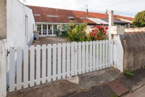a white picket fence in front of a house at La choletaise spacieuse et proche des axes routiers in Cholet