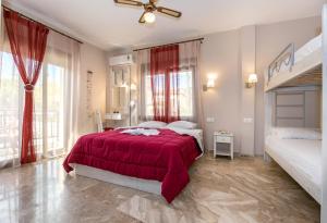 - une chambre avec un lit et une couverture rouge dans l'établissement Agali Villa, à Limenaria