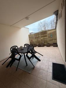 a patio with a table and chairs in a room at Thejungle in Freyming