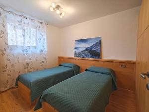 a bedroom with two twin beds and a window at Appartamento panoramico 2 in Candide