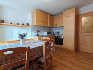 a kitchen with wooden cabinets and a table with chairs at Appartamento panoramico 2 in Candide
