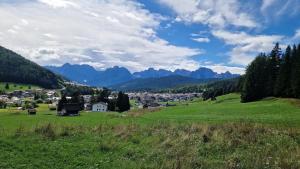 a town in a green field with mountains in the background at Appartamento panoramico 2 in Candide +4 photos