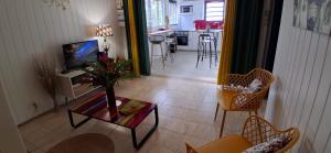 ein Wohnzimmer mit Tisch und Stühlen und eine Küche in der Unterkunft Les Gites Capra - Papaye in Bouillante